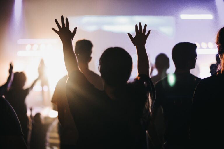 Young adult raising hands during worship service